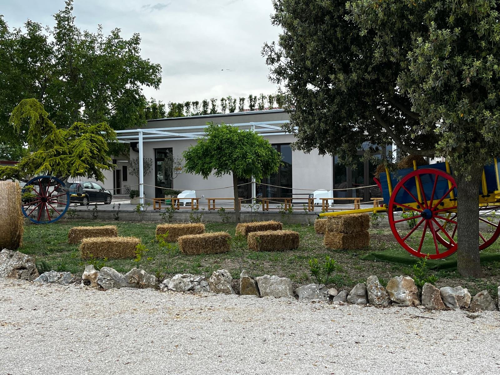 Location esterna del Podere 253 con balle di fieno e ruote colorate